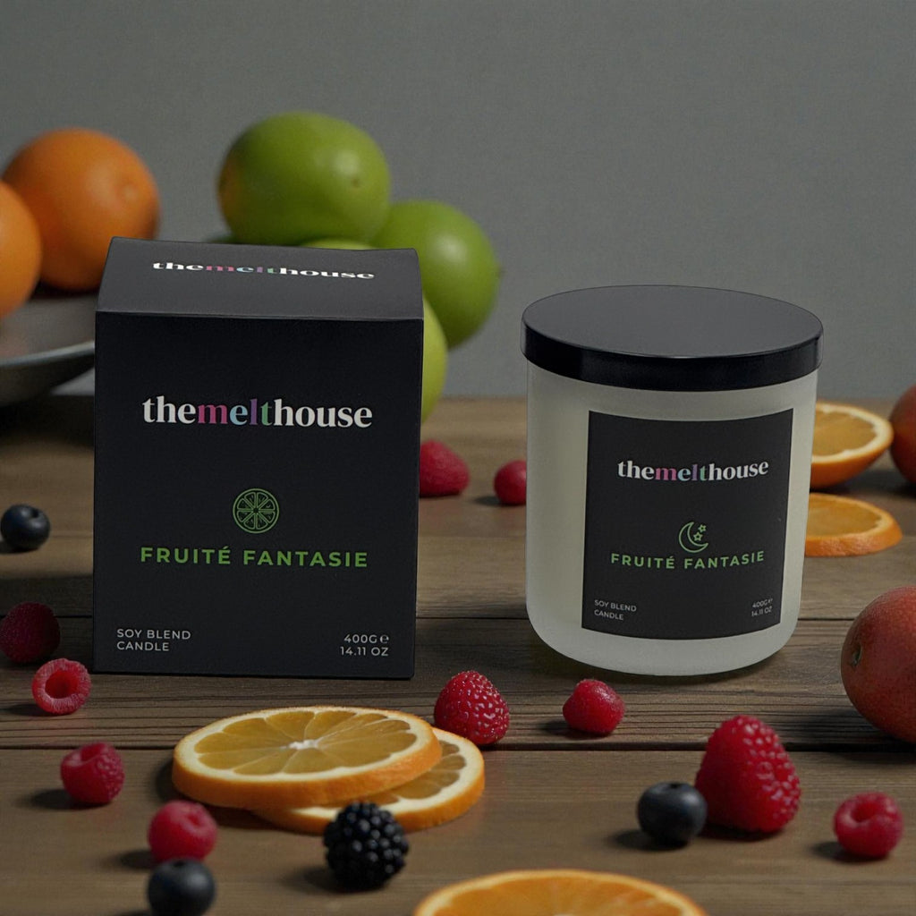 The Melthouse Fruét Fantasie candle and packaging on a wooden surface with fruits.