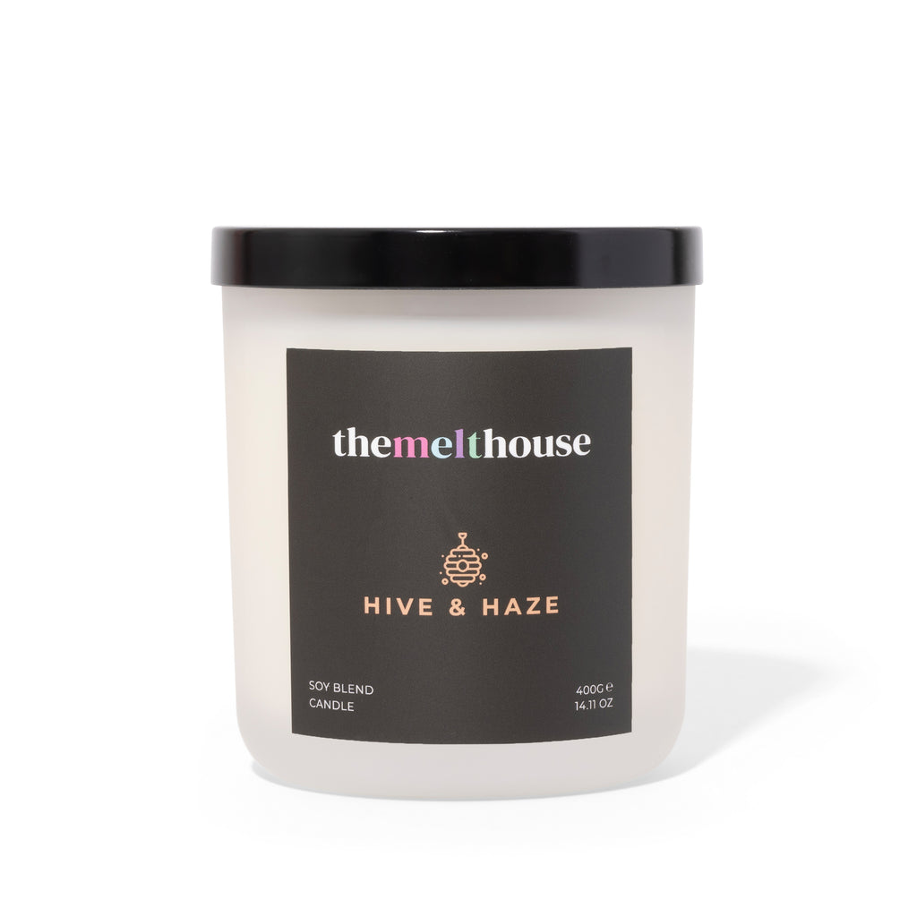 Candle with 'themelthouse' label and 'Hive & Haze' description on a white background